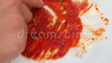 用番茄酱的残留物清空脏盘子。 男人`手在番茄酱的残骸上画一颗心。 4k，慢镜头